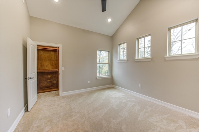 unfurnished bedroom featuring light colored carpet and high vaulted ceiling