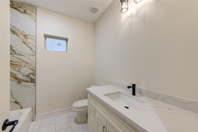 bathroom featuring vanity, a bath, and toilet