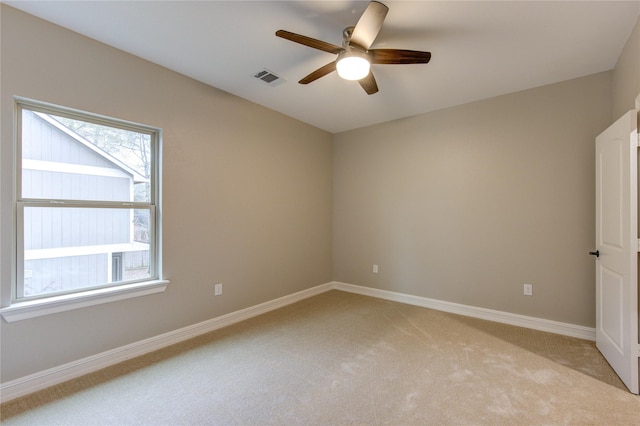 carpeted spare room featuring ceiling fan