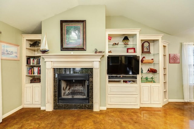 unfurnished living room with vaulted ceiling, a premium fireplace, and carpet