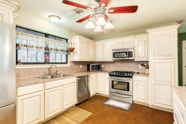 kitchen featuring appliances with stainless steel finishes, sink, backsplash, and ceiling fan