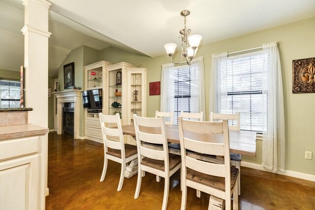 dining room featuring plenty of natural light, decorative columns, and a chandelier