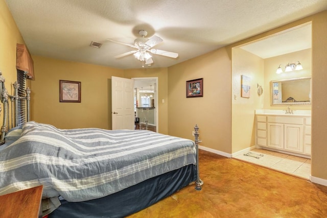 bedroom with ensuite bathroom, sink, ceiling fan, light carpet, and a textured ceiling