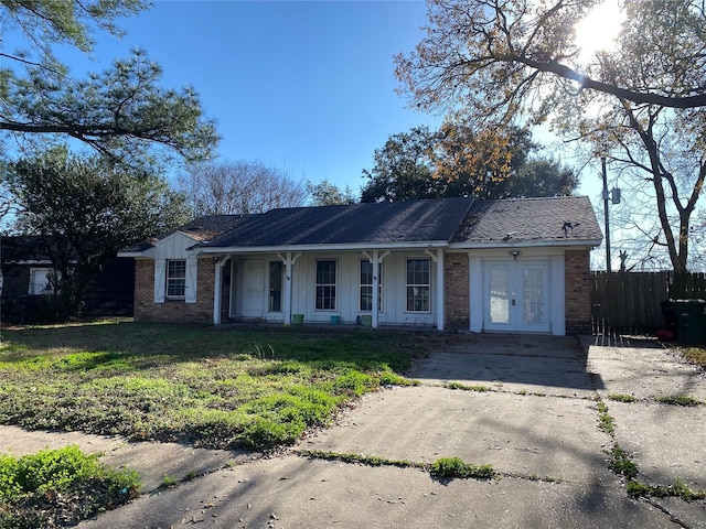 single story home with a front lawn and french doors