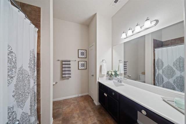 bathroom featuring vanity, curtained shower, and toilet