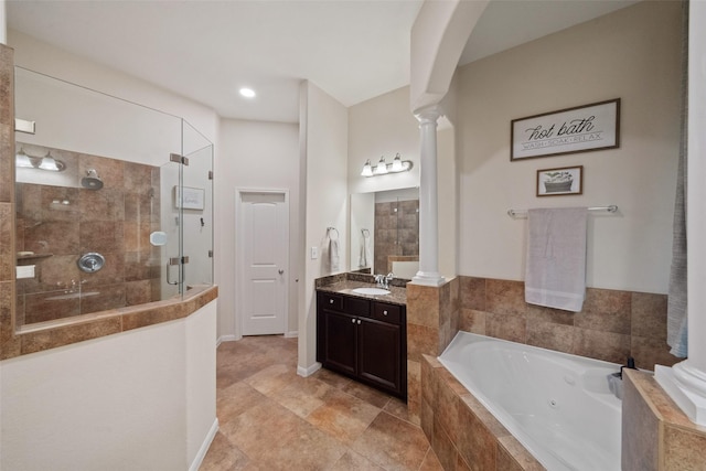 bathroom with ornate columns, vanity, and plus walk in shower