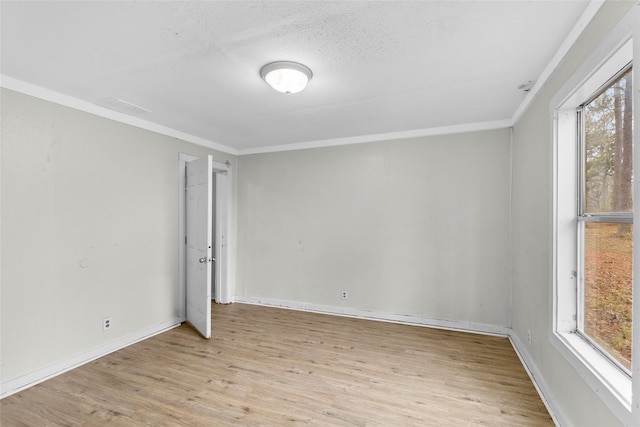 unfurnished room featuring ornamental molding, light hardwood / wood-style floors, a textured ceiling, and a wealth of natural light