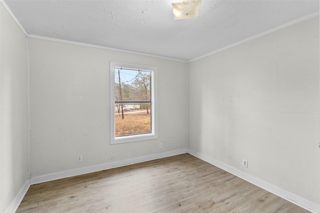 empty room with crown molding, a textured ceiling, and light wood-type flooring