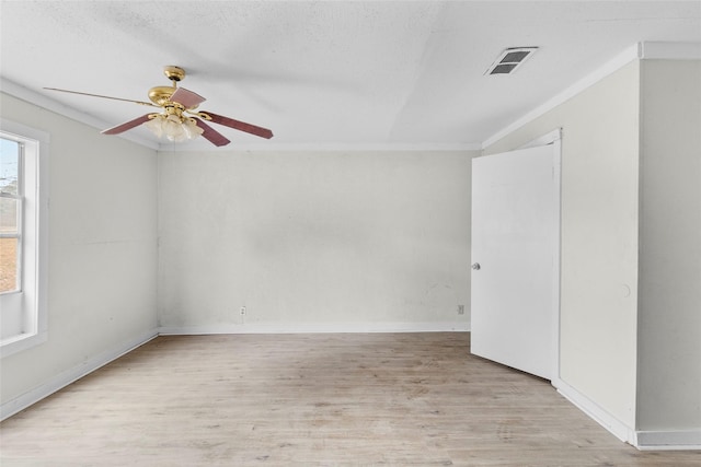 empty room featuring a textured ceiling, light hardwood / wood-style flooring, ornamental molding, and ceiling fan