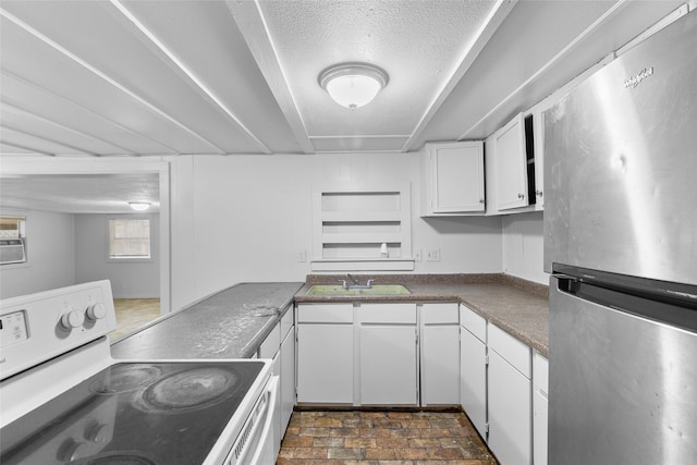 kitchen with stainless steel refrigerator, white cabinetry, sink, white range with electric cooktop, and a textured ceiling