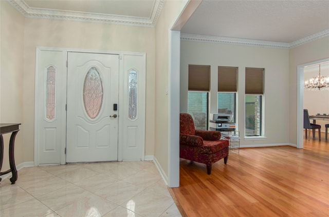 foyer featuring ornamental molding, a chandelier, and light wood-type flooring