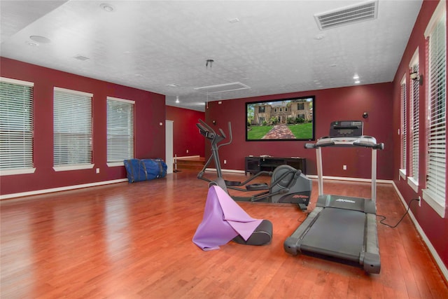 exercise area with hardwood / wood-style flooring and a textured ceiling