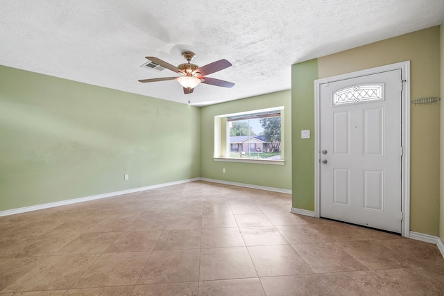 entryway featuring ceiling fan, a textured ceiling, and light tile patterned floors