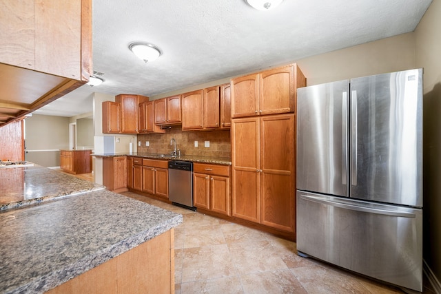 kitchen with tasteful backsplash, sink, stainless steel appliances, and a textured ceiling