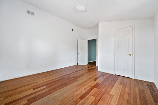 unfurnished bedroom featuring lofted ceiling and wood-type flooring