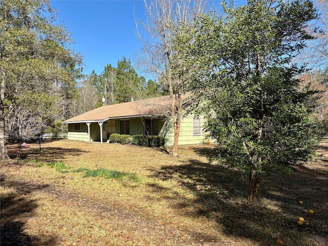 view of side of home with a yard