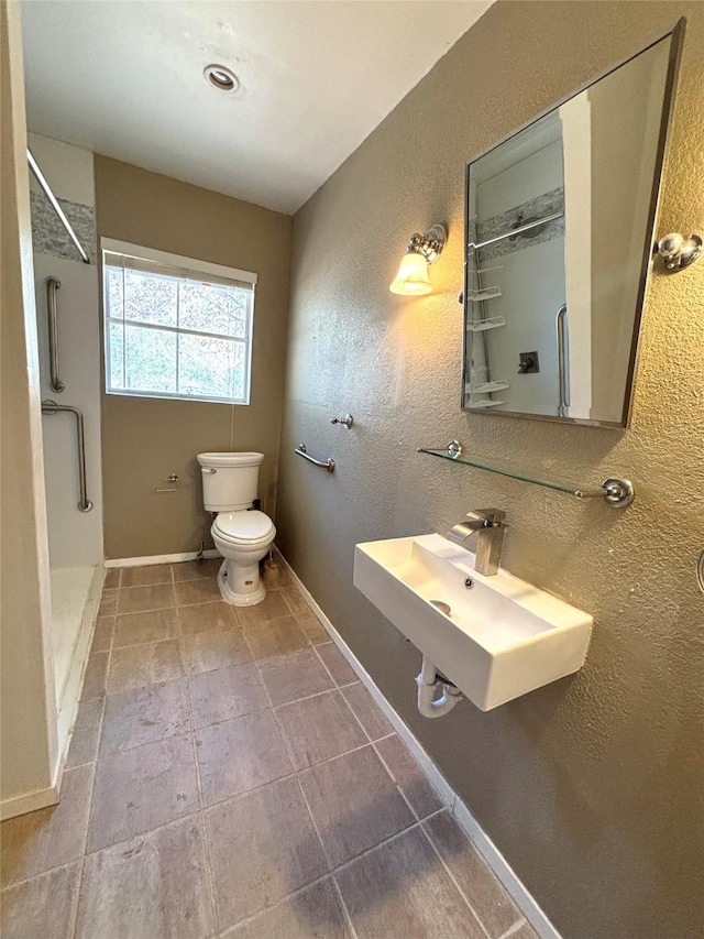 bathroom featuring a shower, sink, and toilet