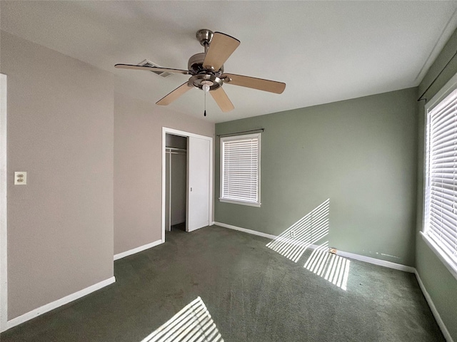 unfurnished bedroom featuring ceiling fan, dark carpet, and a closet