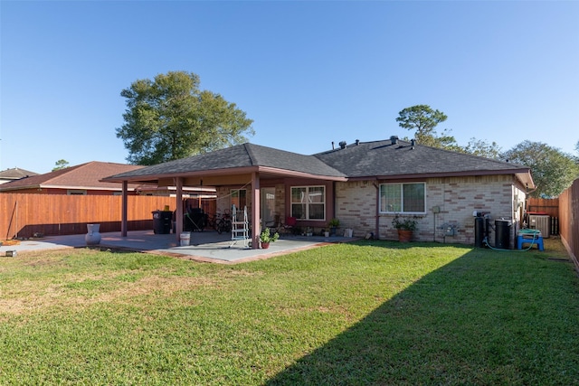 rear view of property featuring a lawn, central air condition unit, and a patio area