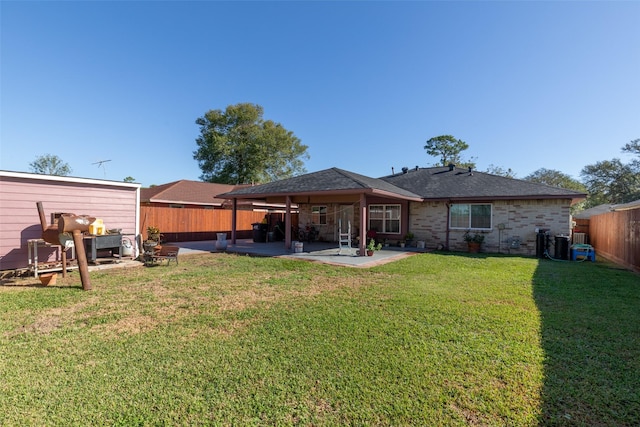 rear view of house featuring a yard and a patio