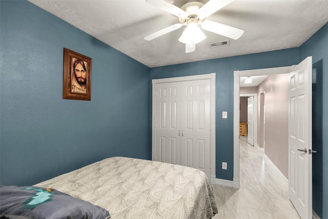 bedroom with ceiling fan, a closet, and a textured ceiling