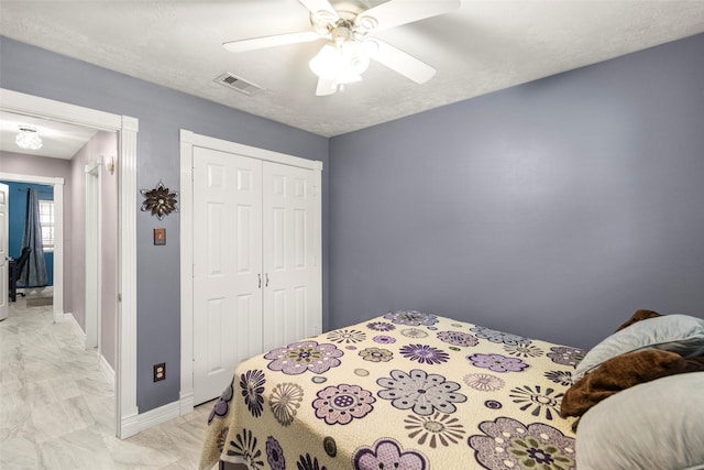 bedroom with a textured ceiling, ceiling fan, and a closet