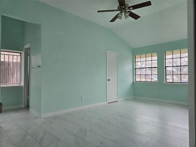 spare room featuring vaulted ceiling, a textured ceiling, and ceiling fan