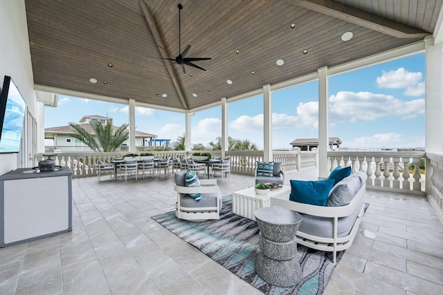 view of patio with an outdoor living space, ceiling fan, and a water view