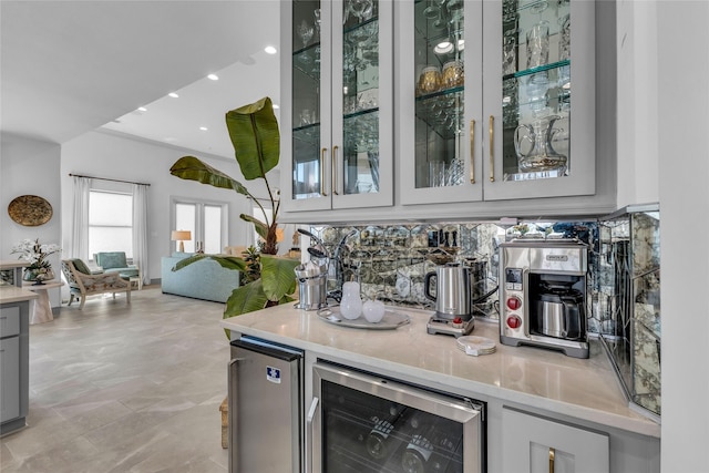 bar with tasteful backsplash, gray cabinetry, and beverage cooler