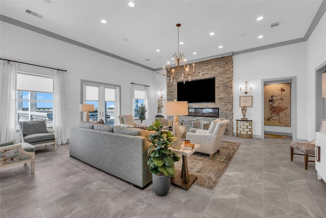 living room featuring an inviting chandelier, crown molding, and a fireplace