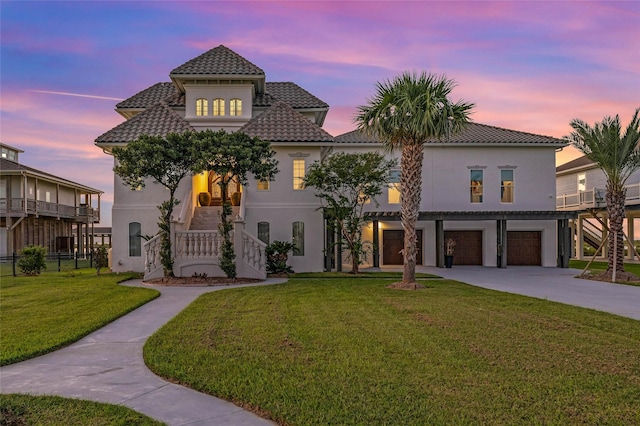 mediterranean / spanish-style home with a garage and a lawn