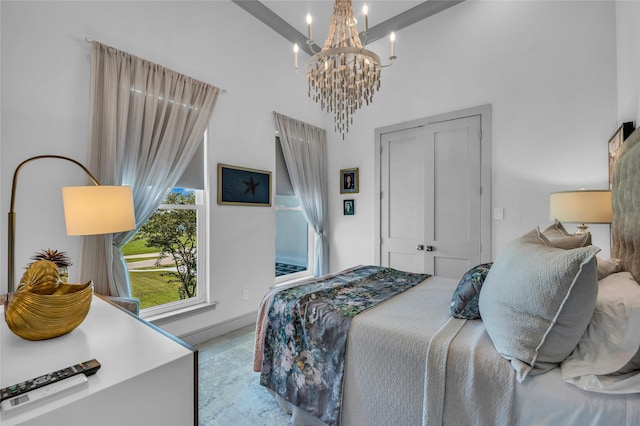 bedroom featuring beam ceiling, a towering ceiling, a closet, and a chandelier