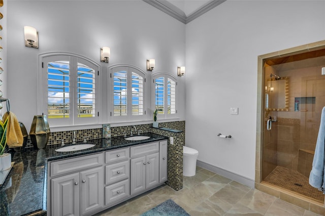 bathroom with water heater, ornamental molding, vanity, toilet, and a shower with door