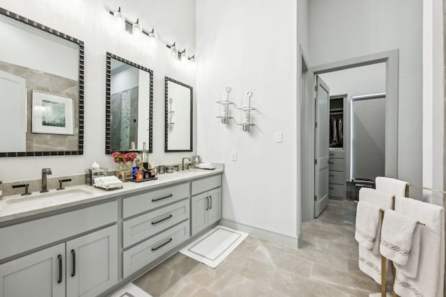 bathroom with tile patterned flooring, vanity, and walk in shower