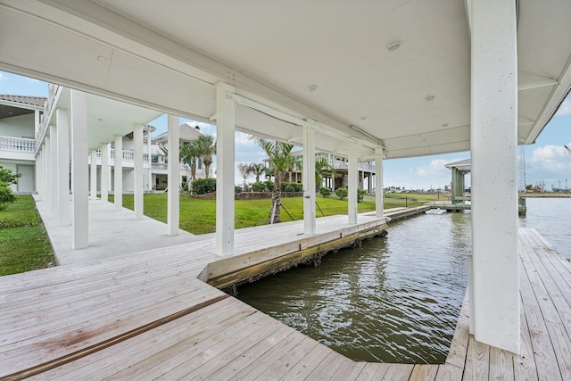 view of dock featuring a water view and a lawn