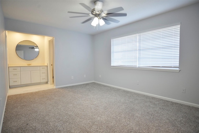 unfurnished bedroom with connected bathroom, light colored carpet, and ceiling fan