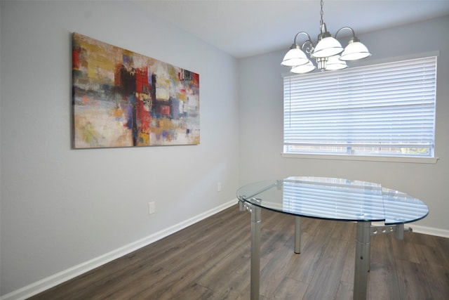 dining area with dark hardwood / wood-style floors and a chandelier