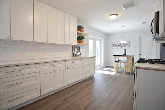 kitchen with white cabinetry, hanging light fixtures, decorative backsplash, and dark hardwood / wood-style flooring