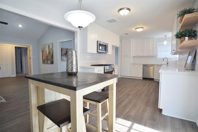 kitchen featuring pendant lighting, sink, white cabinets, and appliances with stainless steel finishes