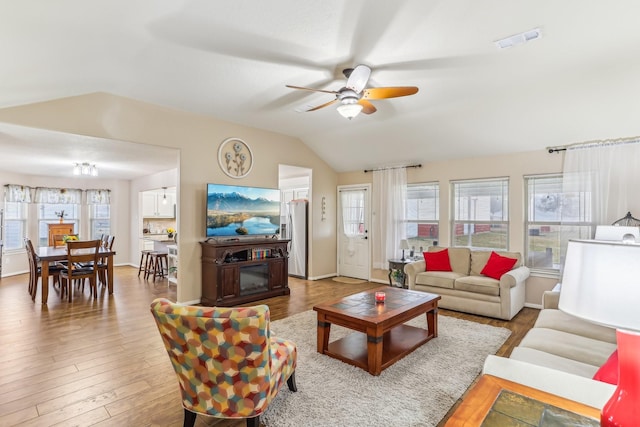 living room with lofted ceiling, hardwood / wood-style flooring, a wealth of natural light, and ceiling fan