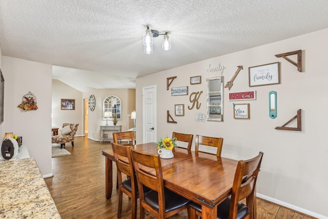 dining area featuring dark hardwood / wood-style floors and a textured ceiling