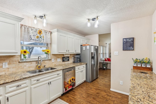 kitchen featuring sink, backsplash, stainless steel appliances, and white cabinets