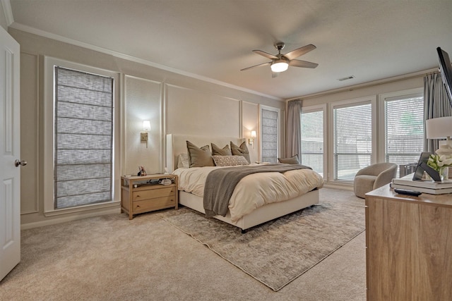 carpeted bedroom featuring crown molding and ceiling fan