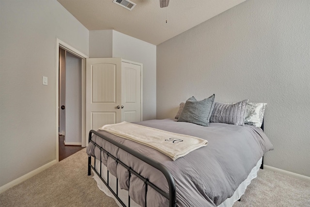 bedroom featuring light colored carpet, a closet, and ceiling fan