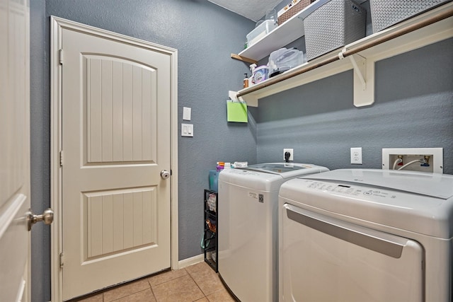 washroom with light tile patterned floors and washer and clothes dryer