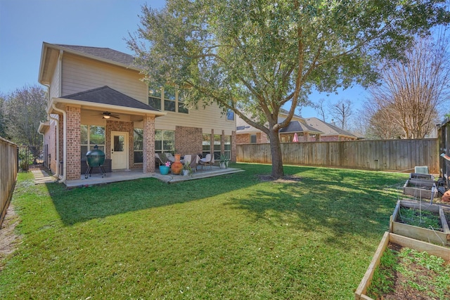 rear view of property featuring a yard, ceiling fan, and a patio area