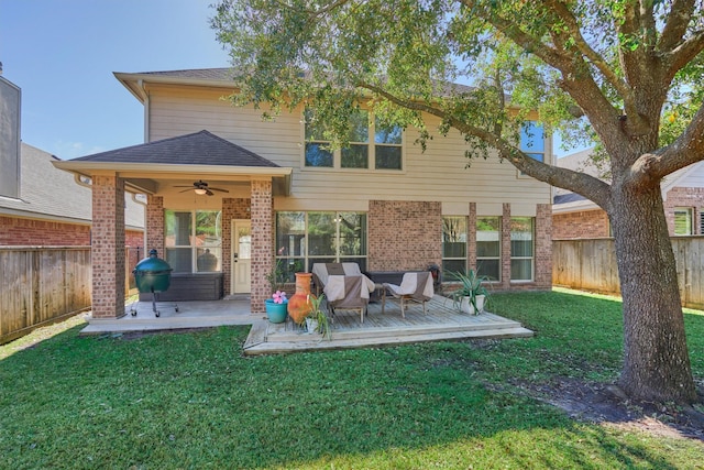 rear view of house with a yard, ceiling fan, and a deck