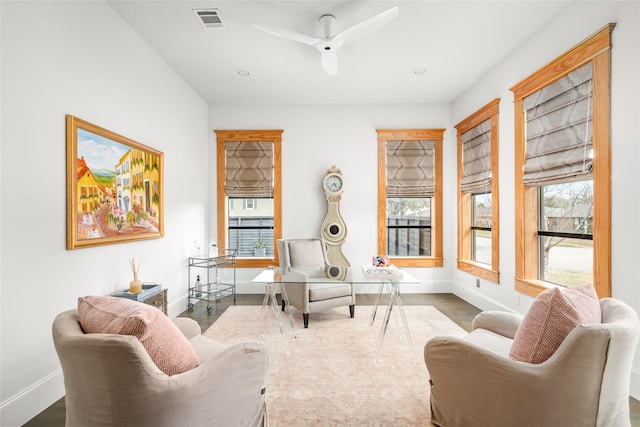 living area featuring ceiling fan and a healthy amount of sunlight