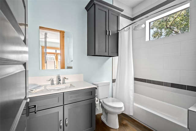 full bathroom featuring hardwood / wood-style flooring, shower / bath combo, vanity, and toilet