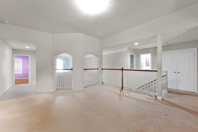 unfurnished room featuring light colored carpet and a textured ceiling